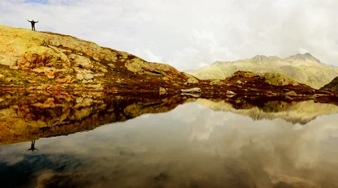 Man hiker standing alone on top of mountain. lake water reflection panorama 스톡 동영상 42948050