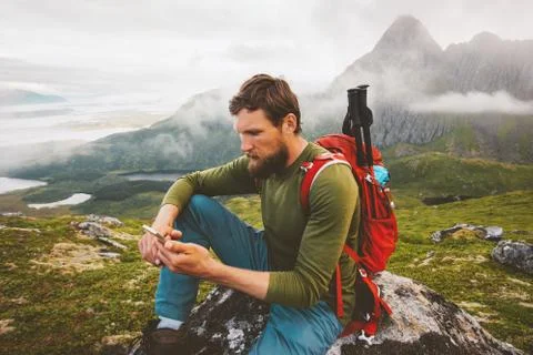 Man hiker using smartphone application navigation in mountains travel blogger Stock Photos