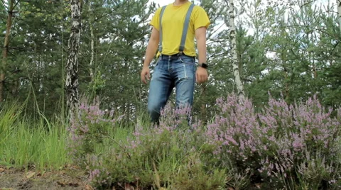 Man hiker walking through the forest and touch smart watch. Yellow T-shirt and Stock Footage 66270086