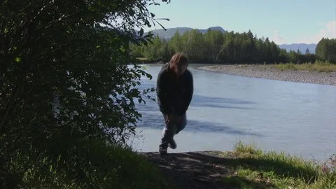 Man hikes edge of small river-Alaska Stock Footage 78940068