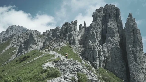 Man Hikes on Path Towards Giant Mountain Peaks Video stock 120413615