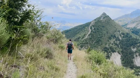 Man Hiking Alone on Mountain Trail, Ground Level View Tracking Shot Stock Footage 338007397