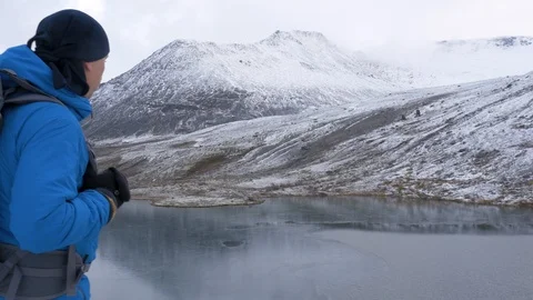 A man is hiking with a backpack, in the mountains. He climbed to the top and Stock Footage 96174743
