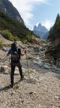 A man with a hiking backpack standing on a pathway in Italian Dolomites Stock Photos