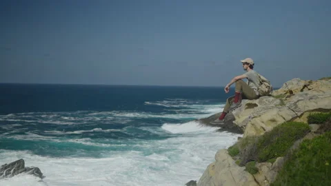 Man hiking close to big cliffs and heavy ocean in Basque Coast, Spain Video stock 154768516