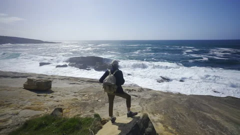 Man hiking close to big cliffs and heavy ocean in Basque Coast, Spain Video stock 154768664