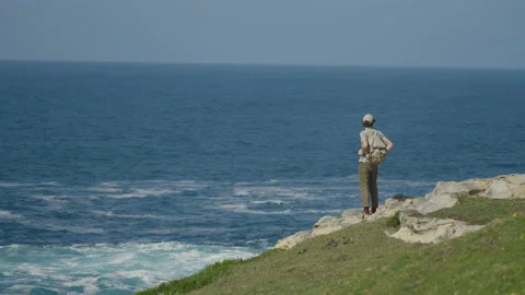 Man hiking close to big cliffs and heavy ocean in Basque Coast, Spain Video stock 154769880