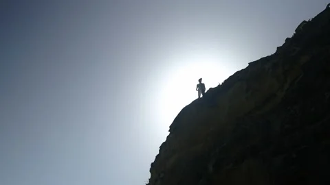 Man hiking close to big cliffs and heavy ocean in Basque Coast, Spain 動画素材 154773426