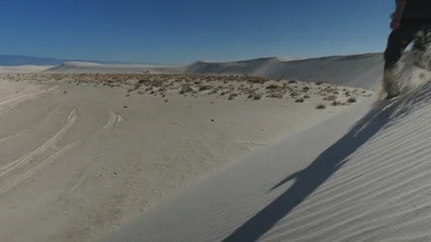 Man hiking down a dune in the desert Stock Footage 102293377