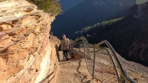 Man Hiking Down Sandstone Cliff Stairs at Wentworth Falls Stock Footage 344943323