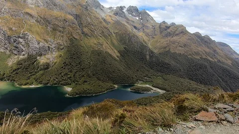 Man Hiking with Epic View of Mountain Ranges and Lake - New Zealand 動画素材 129374014