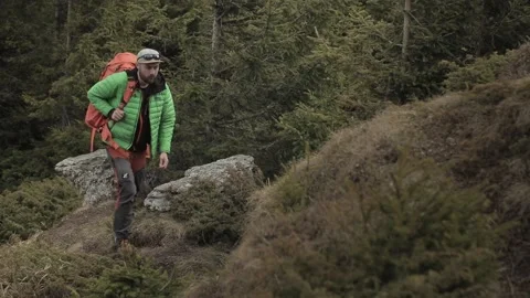 Man hiking on the mountain. Picking the backpack. Outdoor adventure Stock Footage 192833741
