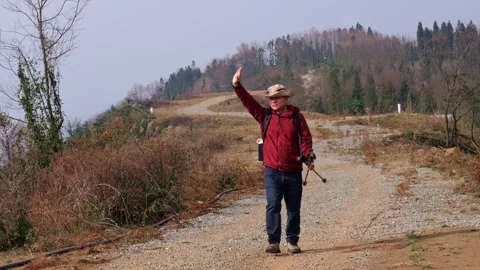 A man hiking on the mountain top is getting baked in the sun Stock Footage 329548004