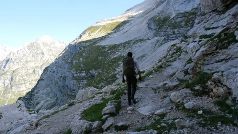 Man hiking to top of a mountain walking on narrow mountain trail with view Stock Footage 161909272