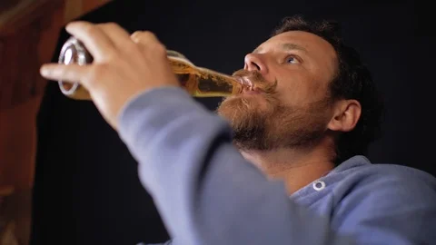 Man hipster with a mustache and beard drinking lager beer from a bottle. 4k Stock Footage 106356335