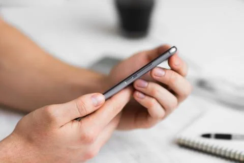 Man Hipster using smartphone a touch screen smart phone in cafe hands close u 库存照片