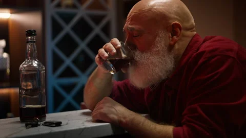 Man in his 50s drinking whiskey before driving home, dangerous DUI behavior Stock Footage 346714156