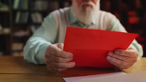 Man in his 60s opening envelope, reading eviction letter, facing housing crisis Stock Footage 314056449