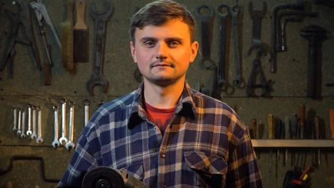 A man in his garage. Looking into the camera and smiling, portrait shooting Stock Footage 126749363