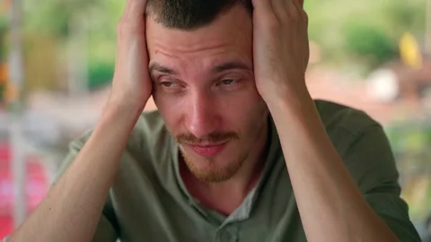 A man with his hands on his head tiredly looking into the distance. Close-up. Video stock 231336312