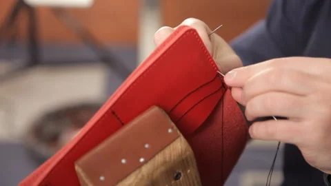 Man with his hands makes a leather wallet. A man of leather stitching wallet Stock Footage 88838039