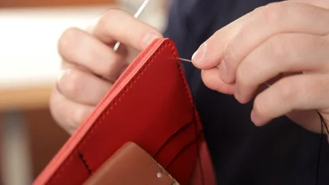 Man with his hands makes a leather wallet. A man of leather stitching wallet 스톡 동영상 88838566