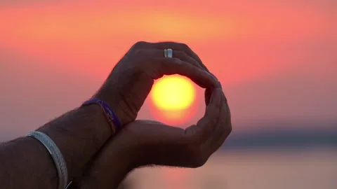 Man in his palms holds the setting sun. Catch the sunset with your hands Stock-Footage 229773471