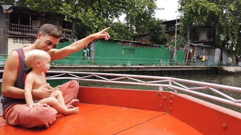 A man with his two-year-old son sitting on the bow of a pleasure boat. Stock Footage 111854059