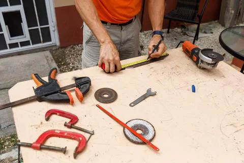 A man in his yard is engaged in locksmith work. Hobby, in a home workshop. Stock Photos