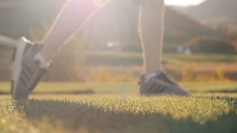 Man hits ball off of tee with sun behind Stock-Footage 102673329