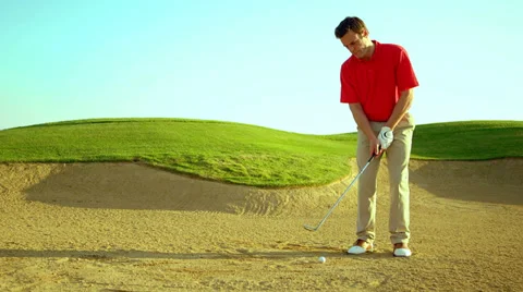 A man hits a golf ball out of a sand trap Stock Footage 33896383