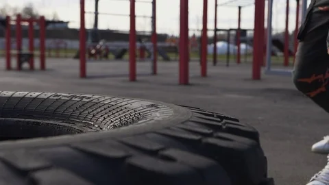 A man hits the hammers on the wheel of a tractor on a sports field on the street Stock Footage 126689467