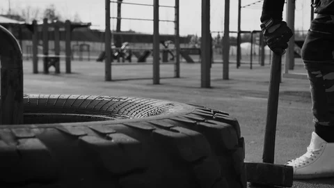 A man hits the wheel with a hammer. Playing sports. Bringing himself into shape. Stock Footage 126373225