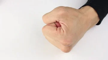 Man hits the white table with his fist and squeezes it hard, closeup Видео 85508975