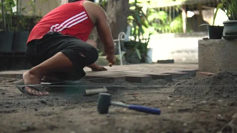 Man Hitting Bricks with Hammer Stone Pavement Construction Stock Footage 160036361