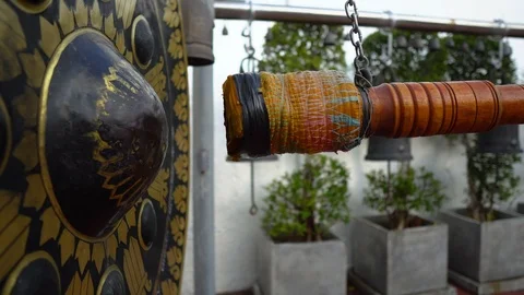 Man Hitting Large Gong at Buddhist Temple in Thailand Stock Footage 122147734