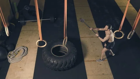 Man hitting tire with sledgehammer Stock Footage 152907065