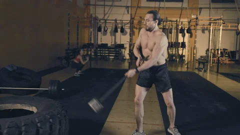 Man hitting tire with sledgehammer Stock Footage 153026487