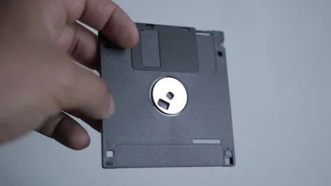 Man hold a 1.44Mb disk from the early 90s, mostly useless today Video stock 167430860