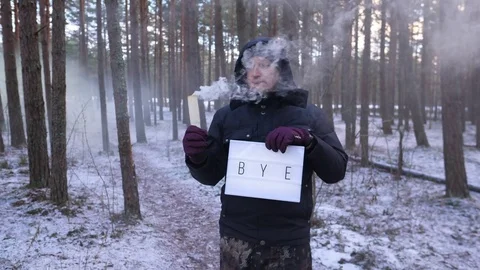 Man hold BYE sign and smoke plume burning out, look straight to camera 動画素材 84180126