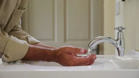 Man hold cupped hands under bathroom faucet, water filled up and overflow Stock Footage 153710999