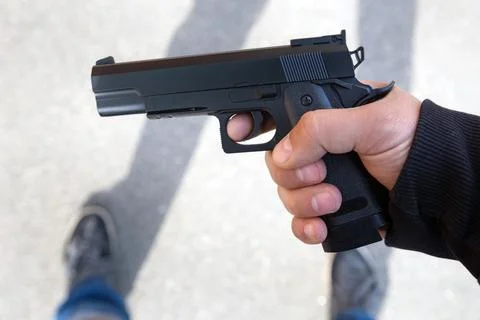 Man hold gun in hand Stock Photos