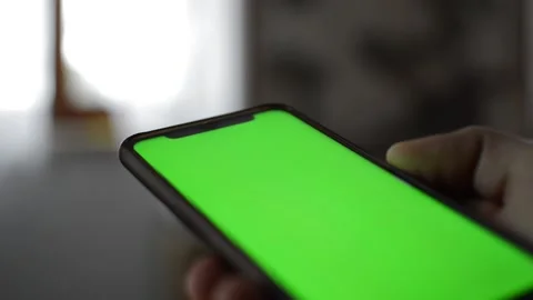 Man hold iphone device by apple with green screen. iphone green screen display. Stock Footage 238787028