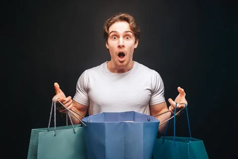Man hold one opened and other clothes shop bags Stock Photos