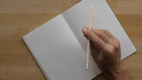 Man hold pencil over empty planner book, thinking how to start 스톡 동영상 91099736