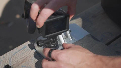 Man hold small action camera and stick it to stunt scooter aluminum deck Stock Footage 260669637