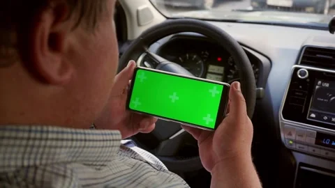 Man hold smartphone with green screen Chroma key with Car dashboard background. Stock Footage 202276305