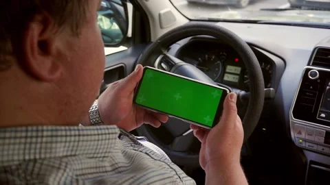 Man hold smartphone with green screen Chroma key with Car dashboard background. Stock Footage 202276394
