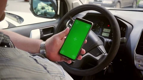 Man hold smartphone with green screen Chroma key with Car dashboard background. Stock Footage 202276397