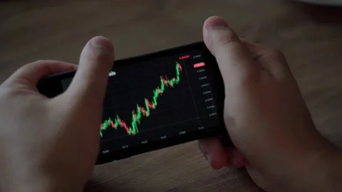 Man hold smartphone look graph crypto currency online. Quotes at stock exchange Stock Footage 157285154